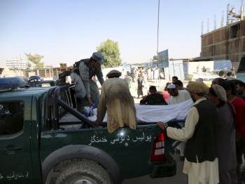 Policías afganos transportan el cadáver de un compañero muerto en el atentado suicida perpetrado contra un convoy de la misión de la OTAN