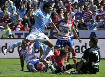 El argentino del Celta Augusto Fernández, contra cuatro jugadores del Granada y el portero. (Foto: M. ÁNGEL MOLINA)