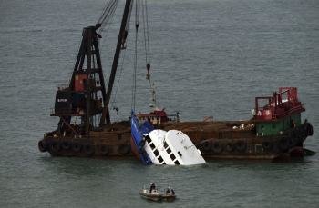 Una grúa saca la embarcación 'Lamma IV', propiedad de la Compañía Eléctrica de Hong Kong, del agua en la isla Lamma