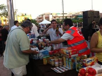 Varios voluntarios de Cruz Roja reparten alimentos a personas con pocos recursos. (Foto: G. HORCAJUELO)