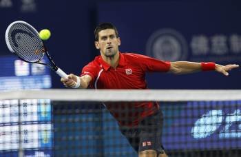 El tenista serbio Novak Djokovic intenta devolver la bola cerca de la red. (Foto: HOW HWEE YOUNG)