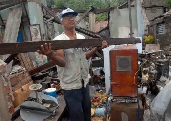 Un hombre rescata sus pertenencias de su casa, destrozada por el paso del huracán. (Foto: MIGUEL RUBIERA)