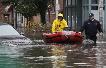 Dos agentes de los equipos de rescate patrullan por las calles inundadas de la localidad de Hoboken, en el estado de Nueva Jersey. (Foto: KENA BETANCUR)