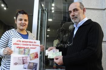 Tania Otero y Carlos Espiña muestran su cartel y dos billeres de 1.000 y 5.000 pesetas. (Foto: MARTIÑO PINAL)