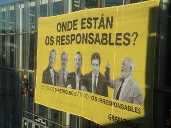 Activistas de Greenpeace han desplegado una pancarta, en la fachada del recinto ferial ExpoCoruña, coincidiendo con la reanudación del juicio por la catástrofe marítima del 'Prestige'