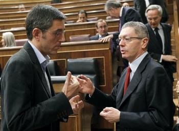 El ministro de Justicia, Alberto Ruiz Gallardón (d), conversa con el secretario general del grupo parlamentario socialista, Eduardo Madina