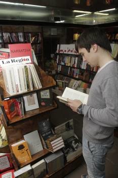 Un joven hojea un libro en la librería de La Región. (Foto: MIGUEL ÁNGEL)