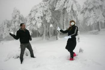 Dos visitantes tirándose bolas de nieve en la estación de montaña, la tarde de ayer. (Foto: MARCOS ATRIO)