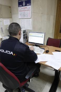 Un agente tramita una denuncia en la Comisaría de As Lagoas. (Foto: XESÚS FARIÑAS)