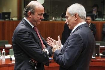 El ministro de Economía español, Luis de Guindos (izq), y el ministro de Finanzas chipriota, Vassos Shiarly (der)