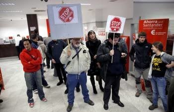 Protesta de Stop Desahucios protestan en una oficina del Santander en Santiago de Compostela. (Foto: LAVANDEIRA)