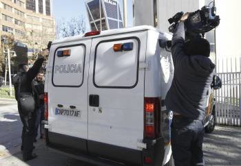 Fotógrafos y cámaras de televisión intentan captar imágenes de Díaz Ferrán dentro del furgón policial. (Foto: ANGEL DÍAZ)