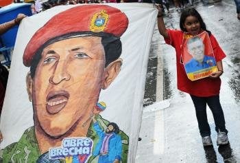 Una niña sostiene una pintura del presidente venezolano Hugo Chávez 