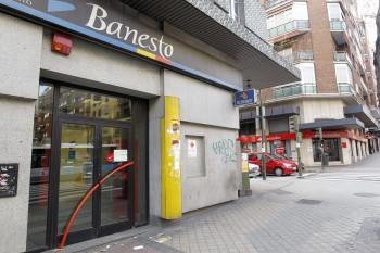 Fachada de una oficina de Banesto y al fondo, otra del Banco de Santander.