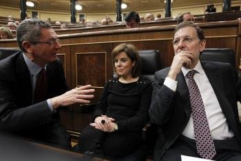 El presidente del Gobierno, Mariano Rajoy (d), junto a la vicepresidenta, Soraya Sáenz de Santamaría, y el ministro de Justicia, Alberto Ruiz-Gallardón