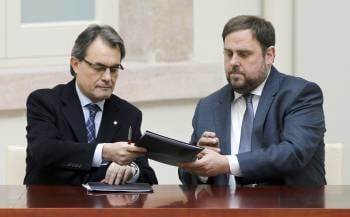 El líder de CiU, Artur Mas, y el presidente de ERC, Oriol Junqueras, durante el acto de la firma. (Foto: ANDREU DALMAU)