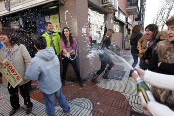 Agraciados de Alcorcón festejan su suerte descorchando espumosos. (Foto: JAVIER LIZÓN)