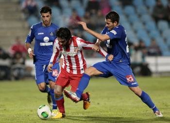 El centrocampista turco del Getafe Arda Turan (c) controla el balón ante la oposición de los jugadores del Getafe, Xavier Torres (d) y Miguel Torres (i) (Foto: EFE)