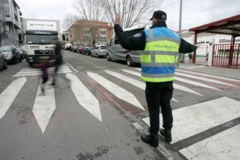 Un agente de la Policía Local regula el tráfico a la salida del colegio Padre Feijóo de Allariz. (Foto: MARCOS ATRIO)