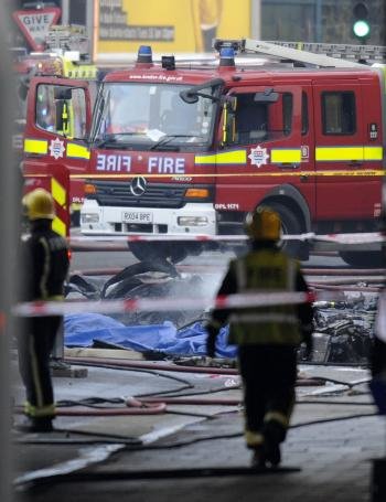  Bomberos y servicios de emergencia trabajan en el lugar donde se ha estrellado un helicóptero en el centro de Londres