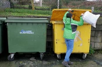 Un niño alaricano deposita una bolsa de residuos en el contenedor amarillo. (Foto: MARCOS ATRIO)