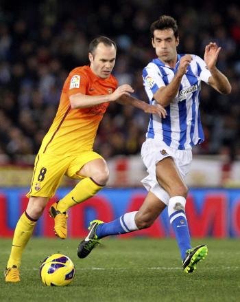 El centrocampista del FC Barcelona Andrés Iniesta (i) pelea un balón con el centrocampista de la Real Sociedad Xabi Prieto (Foto: EFE)