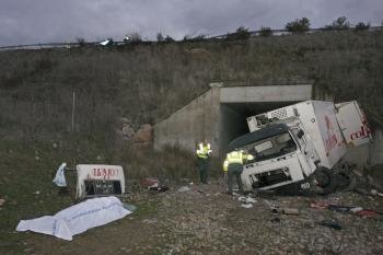 Dos agentes de la Guardia Civil, junto al camión de la empresa Coren accidentado hoy en Ciudad Rodrigo (Salamanca) (Foto: EFE)