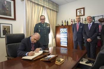 Jorge Fernández-Díaz firma el libro de Honor en la visita a la Escuela de Tráfico de la Guardia Civil de Mérida. (Foto: J. MORALES)