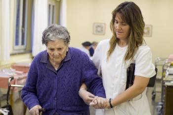 Una asistente ayuda a una mujer en un centro dedicado al cuidado de las personas mayores. (Foto: ARCHIVO)