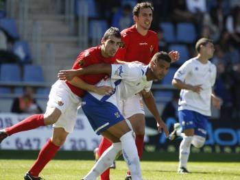 Daniel Portela, central del Ourense, presiona por la espalda al delantero tinerfeño Aridane, máximo goleador del conjunto chicharrero. (Foto: A.C.A.N.)
