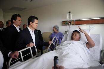 El presidente de México, Enrique Peña Nieto, conversa con uno de los heridos en la explosión en la sede de Pemex.