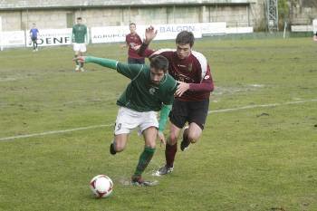 El jugador del Arenteiro Bardelás se lleva el balón ante la marca de un rival del Pontevedra B. (Foto: MIGUEL ÁNGEL)