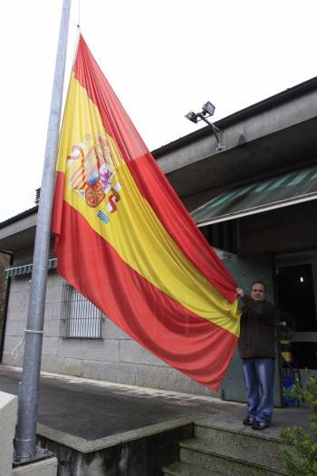 Manuel Rey sujeta la bandera que tiene en su casa.