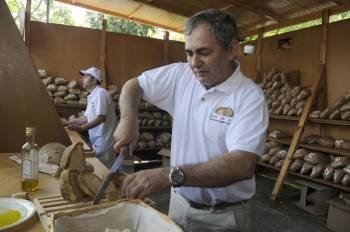 Un productor corta rebanadas de pan de Cea, en uno de los hornos de la localidad. (Foto: MARTIÑO PINAL)