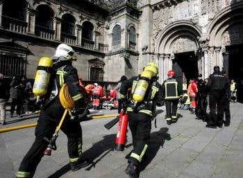 Bomberos, sanitarios y policías, durante el simulacro, en la puerta de Platerías de la catedral. (Foto: XOÁN REY)