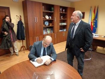 Manuel Baltar firma en el libro de honor de A Rúa, ante Avelino García.