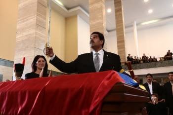 Nicolás Maduro alza la espada de Simón Bolívar sobre el féretro de Hugo Chávez. (Foto: BORIS VERGARA)