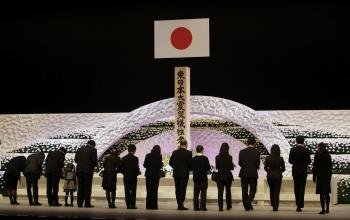 Familiares de las víctimas del terremoto y tsunami que hace dos años asoló el norte de Japón, depositan crisantemos en un altar durante la ceremonia en conmemoración a las víctimas.