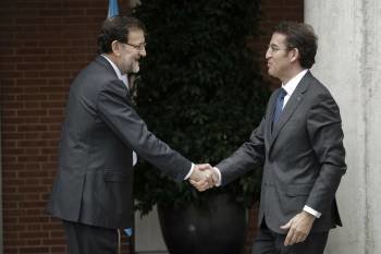 Rajoy saluda a Núñez Feijóo en la puerta del Palacio de la Moncloa. (Foto: EMILIO NARANJO)