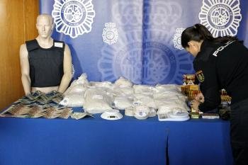 Una agente de la Policía Nacional coloca Los 45 kilos de heroína y resto de material intervenido por las Fuerzas de Seguridad tras la detención del denominado 'Señor de la droga'.