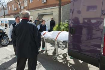 Operarios de una funeraria retiran los cuerpos sin vida del matrimonio. (Foto: E. MARTINENA)