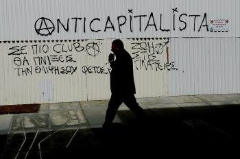  Un hombre camina junto a un mensaje anticapitalista en el centro de Nicosia en Chipre hoy, martes 19 de marzo de 2013 (Foto: EFE)