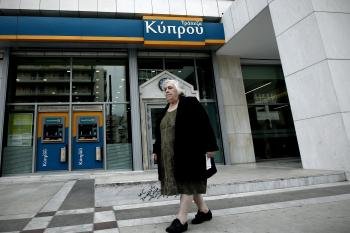 Una anciana pasa delante de la sede del Banco de Chipre.