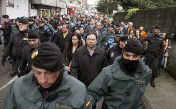 El alcalde y miembros de su corporación de Ponteareas, escoltados por las fuerzas del orden. (Foto: SALVADOR SAS)