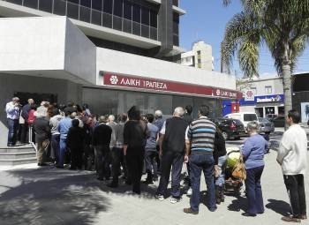 Numerosas personas hacen cola para entrar en una sucursal del Laiki Bank. (Foto: STRINGER)
