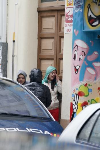 Familiares de la mujer asesinada, ante las puertas del domicilio donde se produjo la agresión. (Foto: ELISEO TRIGO)