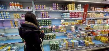Una clienta de un supermercado busca en un panel repleto de yogures dispuestos para su venta. (Foto: JUANJO MARTÍN)