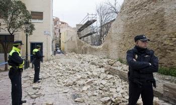Varios agentes rodean la zona acordonada donde a primera hora de esta mañana se han derrumbado 30 metros lineales de la muralla medieval de Zaragoza.
