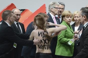  El presidente ruso, Vladimír Putin, y la canciller alemana, Angela Merkel , se ven sorprendidos por una activista de Femen.