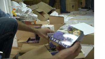 Un agente examina durante un registro algunos de los productos falsificados. (Foto: GUARDIA CIVIL)